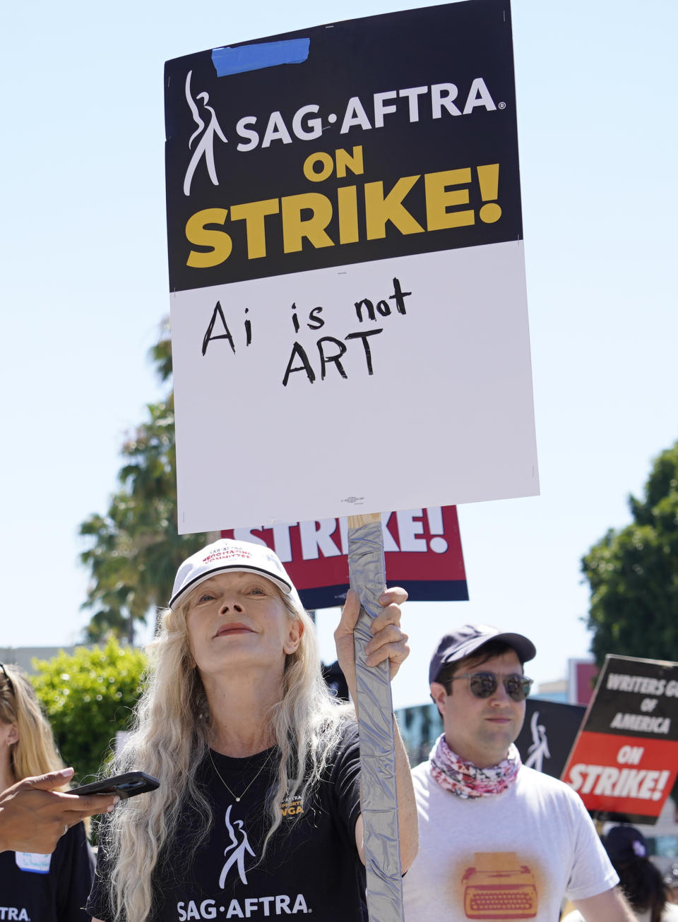 La actriz Frances Fisher sostiene un cartel que dice "IA no es arte" en un mitin de guionistas y actores en huelga fuera de los estudios Paramount en Los Ángeles el viernes 14 de julio de 2023. Los guionistas y actores piden garantías ante el uso de la tecnología. (Foto AP/Chris Pizzello)