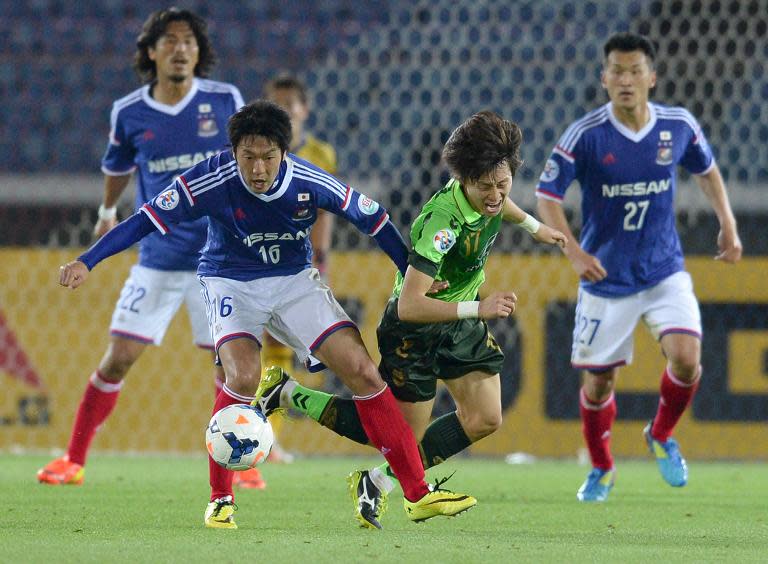 Yokohama F.Marinos forward Sho Ito (#16/2nd left) battles for the ball with Jeonbuk Hyundai Motors midfielder Lee Jae-Sung (#17/2nd right) during an AFC Champions League game in Yokohama on April 15, 2014