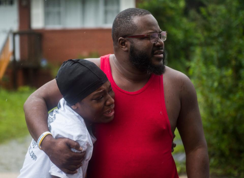 A father and daughter learn that friends were injured and later died when a tree fell on their house during landfall of Hurricane Florence in Wilmington, North Carolina on Friday.