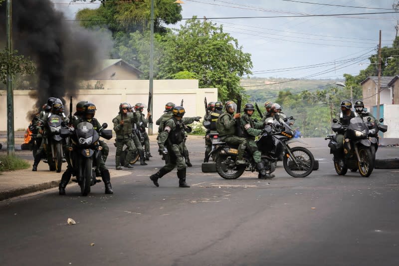 Les gardes nationaux vénézuéliens en patrouille dans la ville de Ciudad Bolivar. Trois personnes sont mortes et plus de 400 autres ont été arrêtées depuis le week-end au Venezuela lors de manifestations ou de pillages provoqués par la suppression des billets de 100 bolivars, la plus forte valeur en circulation. /Photo prise le 17 décembre 2016/REUTERS/William Urdaneta