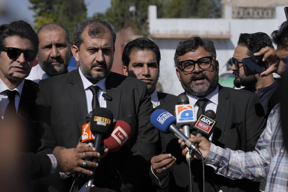 Umair Niazi, second left, and Usman Gill, second right, lawyers of Pakistan former Prime Minister Imran Khan's legal team, talk to media members after a special court hearing of the Cipher case against Khan, outside the Adiyala prison, in Rawalpindi, Pakistan, Monday, Oct. 23, 2023. A Pakistani court indicted Khan on charges of revealing official secrets after his 2022 ouster from office, the strongest indication yet the former prime minister may be unable to run in the upcoming parliamentary elections in late January. (AP Photo/Anjum Naveed)