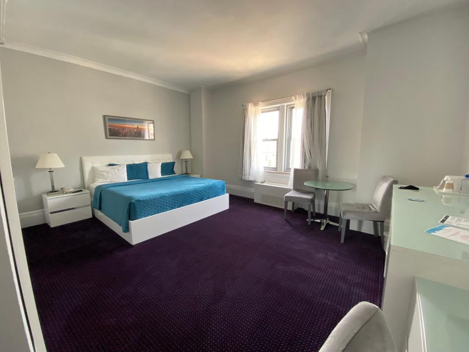 the hotel room with purple carpet and blue bed spread at congress plaza hotel chicago