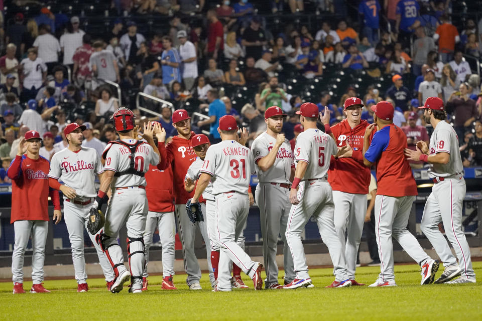 The Philadelphia Phillies celebrate after defeating the New York Mets in a baseball game, Saturday, Sept. 18, 2021, in New York. The Phillies won 5-3. (AP Photo/Mary Altaffer)