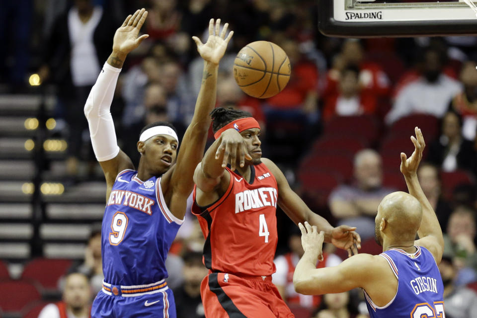 Houston Rockets forward Danuel House Jr. (4) passes the ball as New York Knicks guard RJ Barrett (9) and forward Taj Gibson, right, defend during the first half of an NBA basketball game, Monday, Feb. 24, 2020, in Houston. (AP Photo/Eric Christian Smith)