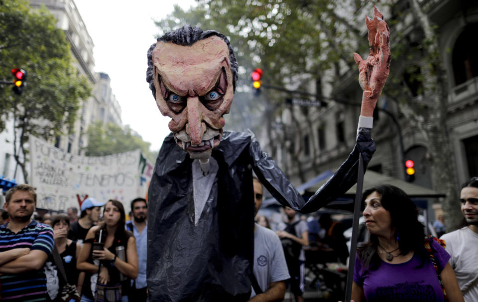 Manifestantes marchan mientras sostienen un títere gigante que representa al presidente Mauricio Macri durante una protesta en Buenos Aires, Argentina, el jueves 30 de marzo de 2017. Sindicatos y organizaciones sociales se manifiestan contra el mandatario. (AP Foto/Natacha Pisarenko)