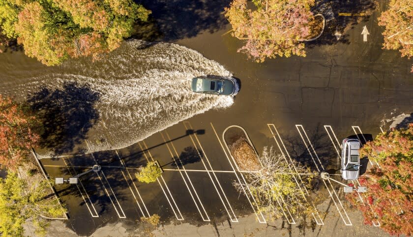 A car crosses a flooded parking lot in Oroville, Calif., on Monday, Oct. 25, 2021.