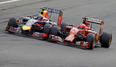 Red Bull Formula One driver Daniel Ricciardo of Australia (L) overtakes Ferrari driver Kimi Raikkonen of Finland during the Italian F1 Grand Prix in Monza September 7, 2014. REUTERS/Max Rossi