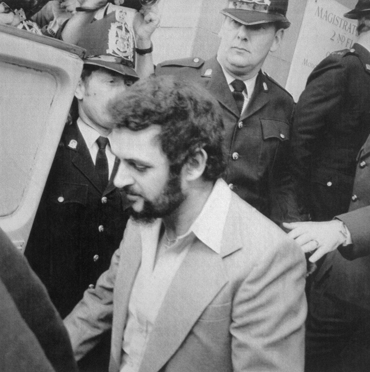 Yorkshire Ripper, Peter Sutcliffe, is shown leaving court under heavy police guard. (Getty)