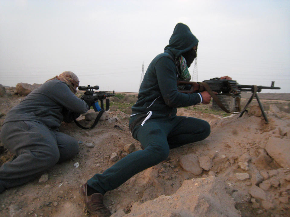 In this Thursday, Jan. 23, 2014 photo, gunmen take up combat positions in Fallujah, Iraq. Islamic militants controlling a mainly Sunni area west of Baghdad are so well-armed that they could occupy the capital, members of Iraq's al-Qaida branch - known as the Islamic State of Iraq and the Levant - have taken over parts of Ramadi, the capital of the largely Sunni western province of Anbar. (AP Photo)