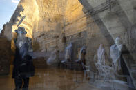 Ultra Orthodox Jewish men are seen reflected in a window as they pray ahead of the Jewish new year at the Western Wall, the holiest site where Jews can pray in Jerusalem's old city, Wednesday, Sept. 16, 2020. A raging coronavirus outbreak is casting a shadow over the normally festive Jewish New Year. With health officials recommending a nationwide lockdown, traditional family gatherings will be muted, synagogue prayers will be limited to small groups and roads will be empty. (AP Photo/Sebastian Scheiner)