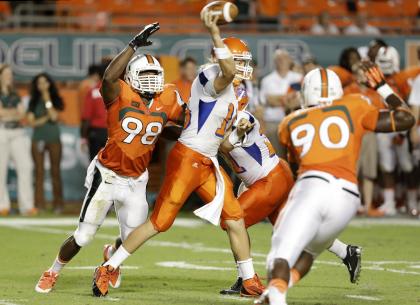 Savannah State quarterback Zach Hutchenson (15) passes as he is pressured by Miami defensive end Al-Quadin Muhammad (98). (AP Photo/Lynne Sladky)