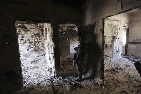 A Free Syrian Army fighter holds a weapon as he stands inside a room in Deir al-Zor September 28, 2013. REUTERS/Khalil Ashawi