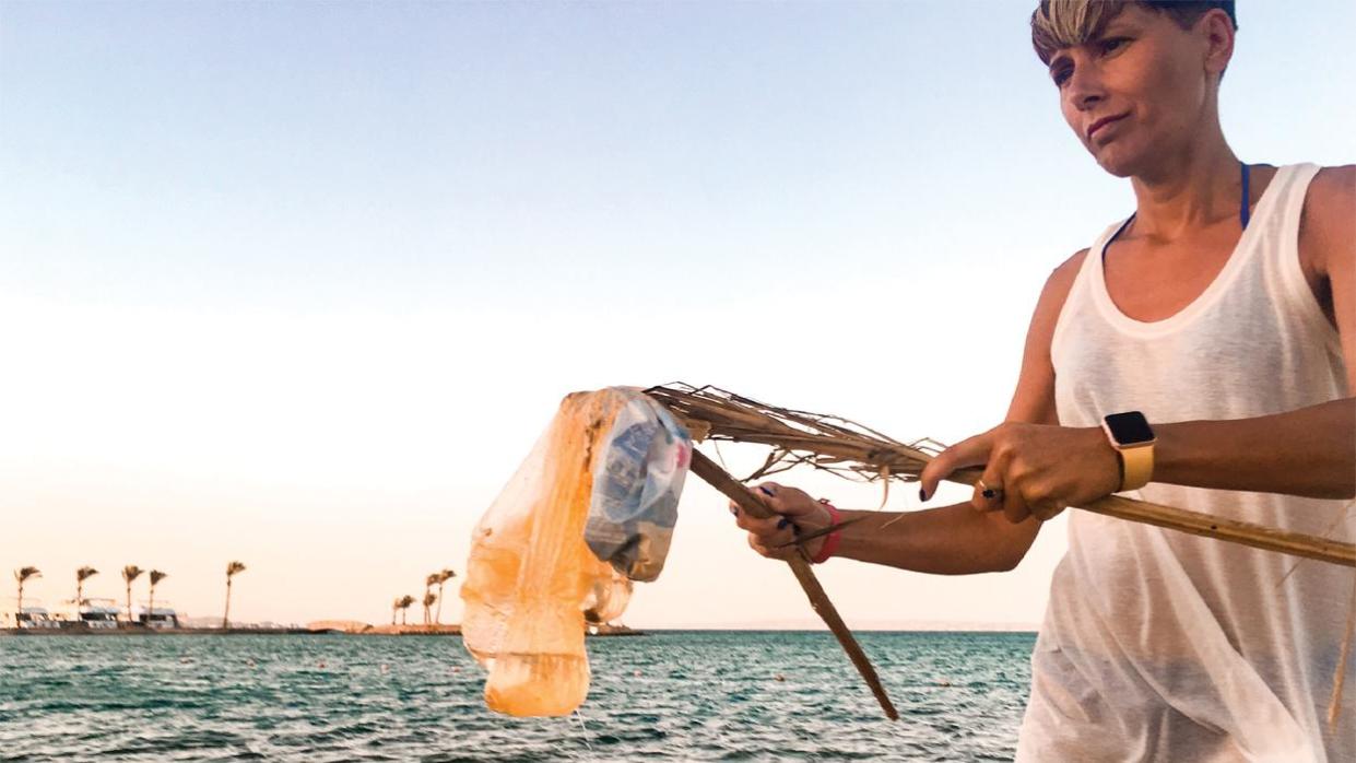 Woman cleaning up beach 