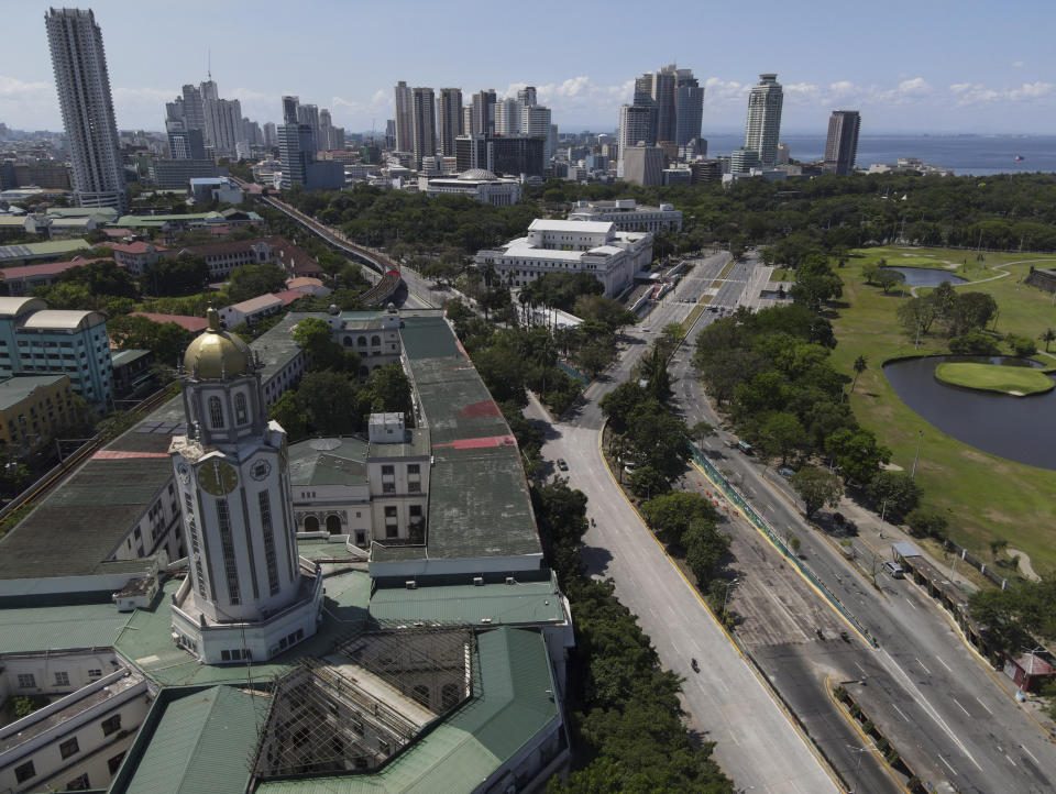 The Manila City Hall stands beside an almost empty road as the government implements a strict lockdown to prevent the spread of the coronavirus on Good Friday, April 2, 2021 in Quezon city, Philippines. Filipinos marked Jesus Christ's crucifixion Friday in one of the most solemn holidays in Asia's largest Catholic nation which combined with a weeklong coronavirus lockdown to empty Manila's streets of crowds and heavy traffic jams. Major highways and roads were eerily quiet on Good Friday and churches were deserted too after religious gatherings were prohibited in metropolitan Manila and four outlying provinces. (AP Photo/Aaron Favila)