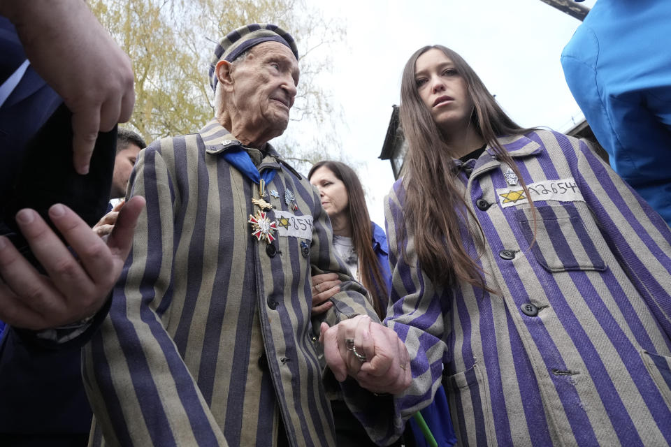 CAPTION CORRECTS THE NAME - Auschwitz Survivor from the U.S. Edward Mosberg, left, and his granddaughter prepare for the March of the Living annual observance that was not held for two years due to the global COVID-19 pandemic, in Oswiecim, Poland, Thursday, April 28, 2022. Only eight survivors and some 2,500 young Jews and non-Jews are taking part in the annual march that is scaled down this year because of the war in neighboring Ukraine that is fighting Russia's invasion. (AP Photo/Czarek Sokolowski)