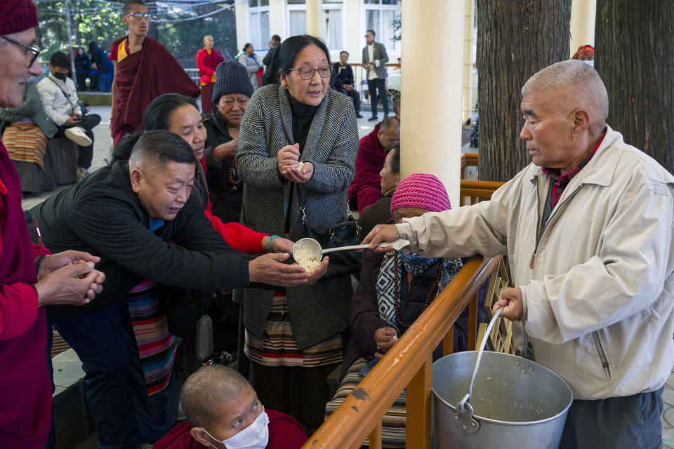 An exile Tibetan distributes sweetened rice as refreshments at an event marking the anniversary of the awarding of the Nobel Peace Prize to the Dalai Lama in Dharamshala, India, Sunday, Dec. 10, 2023. (AP Photo/Ashwini Bhatia)