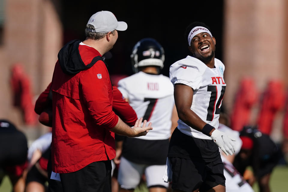 Atlanta Falcons wide receiver Russell Gage (14) laughs as he walks past head coach Arthur Smith during their NFL training camp football practice Sunday, Aug. 1, 2021, in Flowery Branch, Ga. (AP Photo/John Bazemore)