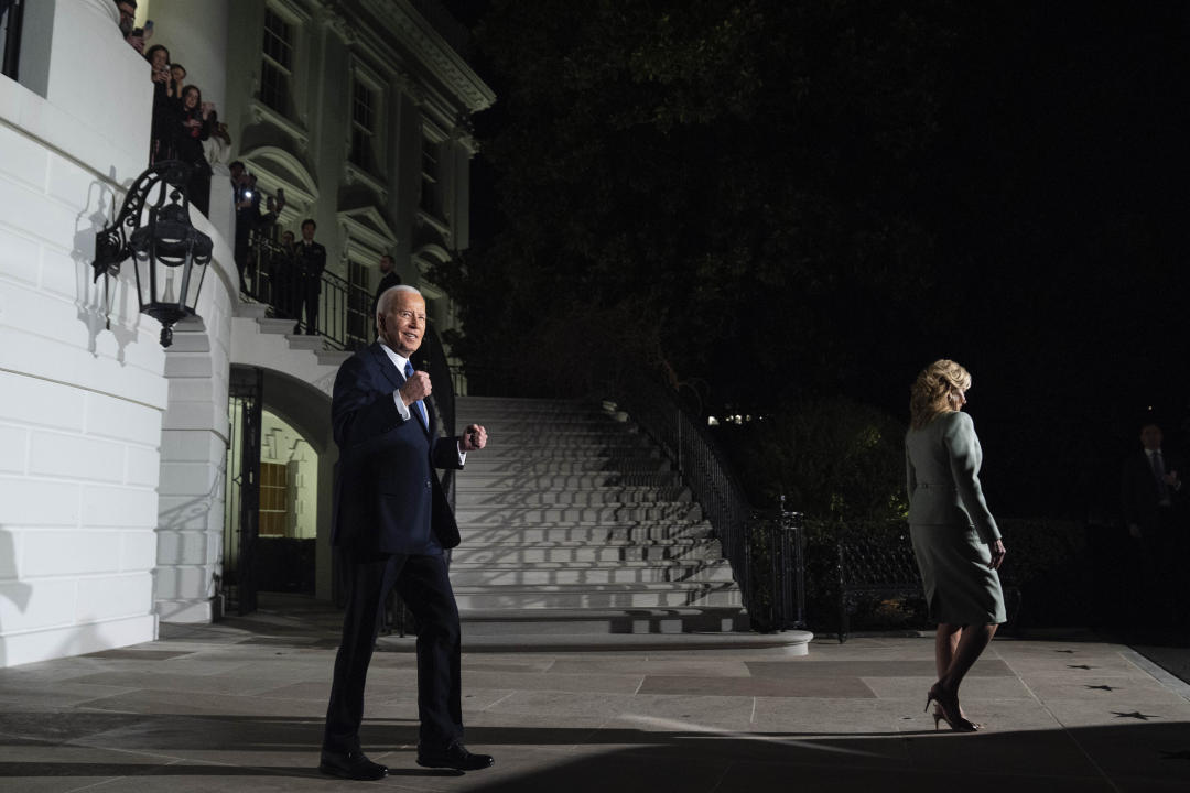 President Biden pumps his fists as he and first lady Jill Biden depart the White House Thursday.