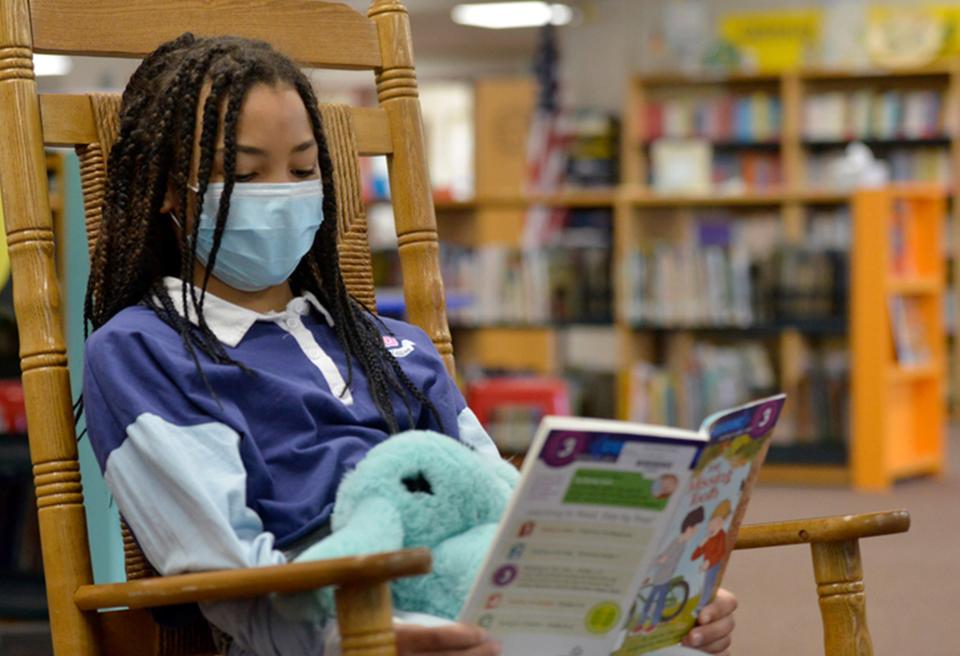 A third-grade student sits in a rocking chair in the school library in Provincetown, in 2022.