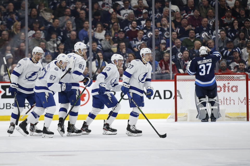 Tampa Bay Lightning's Carter Verhaeghe (23) and teammates celebrate his goal against Winnipeg Jets goaltender Connor Hellebuyck (37) during second-period NHL hockey game action in Winnipeg, Manitoba, Friday, Jan. 17, 2020. (John Woods/The Canadian Press via AP)