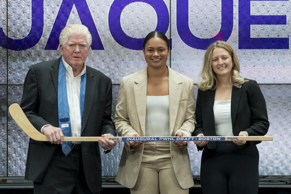 FILE - Sophie Jacques, center, from the NCAA, poses with executive director of the Professional Women's Hockey Players Association Brian Burke, left, and Boston general manager Danielle Marmer, right, after being selected 10th overall by Boston during the second round of the inaugural Professional Women's Hockey League draft in Toronto, Monday, Sept. 18, 2023. The title of general manager doesn’t completely capture the myriad of tasks on Danielle Marmer’s to-do list in the two months since taking over the Professional Women’s Hockey League franchise in Boston. (Spencer Colby/The Canadian Press via AP, File)