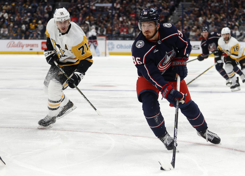 Columbus Blue Jackets forward Jack Roslovic, right, controls the puck in front of Pittsburgh Penguins forward Evgeni Malkin during the second period of an NHL hockey game in Columbus, Ohio, Saturday, Oct. 22, 2022. (AP Photo/Paul Vernon)