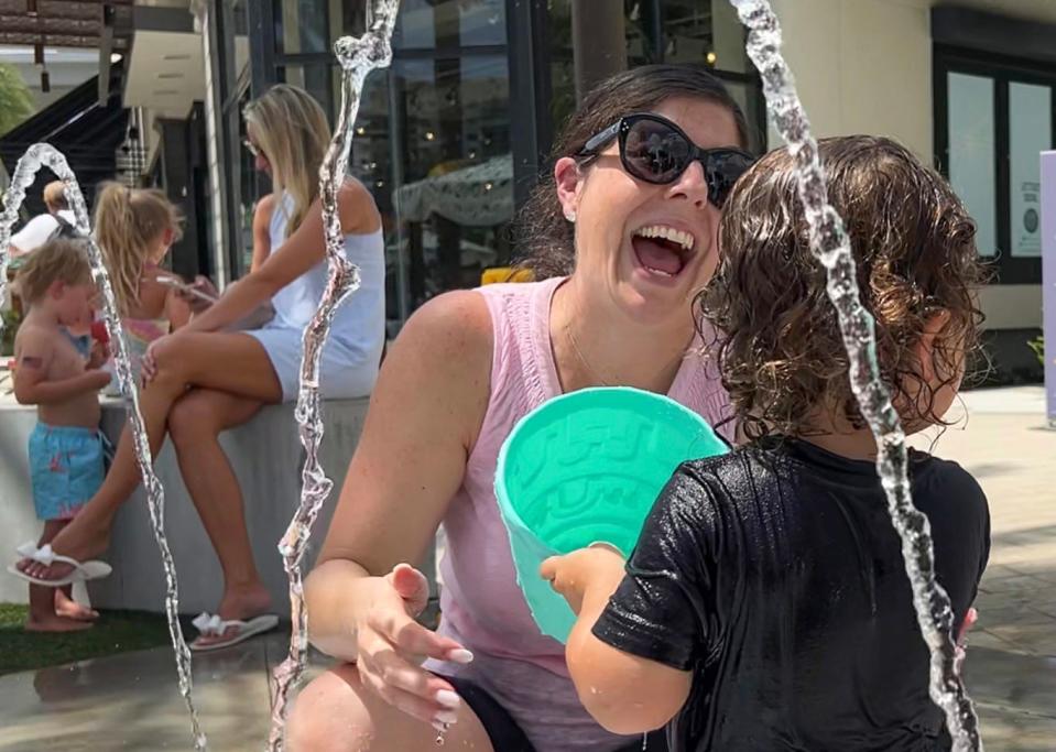 Christy Brenman laughs with her 2-year-old son Theo during July Summer Splash at Downtown Palm Beach Gardens.