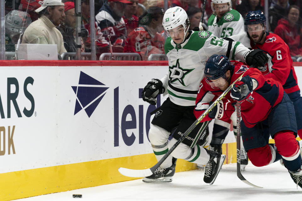 Dallas Stars center Wyatt Johnston (53) and Washington Capitals defenseman Nick Jensen (3) battle for control of the puck during the second period of an NHL hockey game, Thursday, Dec. 7, 2023, in Washington. (AP Photo/Stephanie Scarbrough)