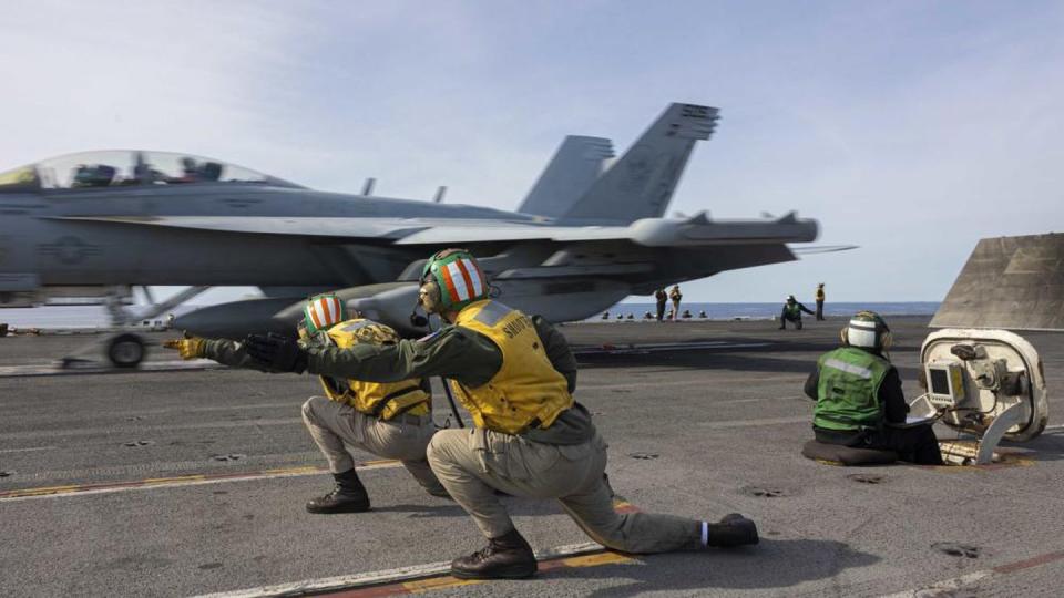 Lt. Cmdr. Andrew Castro, front, and Lt. Bartley O'Toole shoot off an EA-18G Growler jet as it launches from the aircraft carrier Abraham Lincoln Dec. 2, 2022. (MC3 Clayton A. Wren/Navy)
