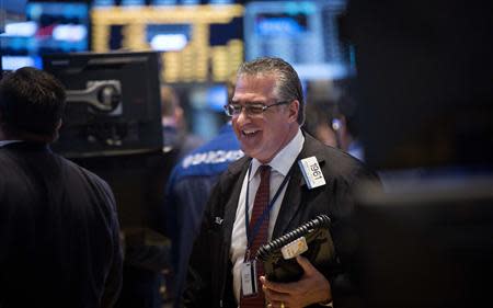 Trader Kenneth Polcari smiles as he works on the floor of the New York Stock Exchange at the market opening in New York, December 23, 2013. REUTERS/Carlo Allegri