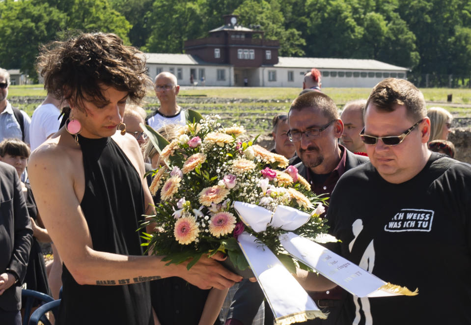 People lay a wreath in remembrance for prisoners assigned a pink triangle in the former Nazi concentration camp Buchenwald within the Christopher Street Day in Weimar, Germany, Sunday, June 23, 2019. There were 650 prisoners assigned a pink triangle in the Buchenwald concentration camp between 1937 and 1945. Many of them lost their lives. (AP Photo/Jens Meyer)