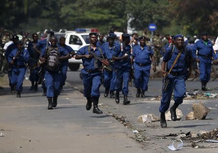 Policemen run towards protesters during a protest against President Pierre Nkurunziza's decision to run for a third term in Bujumbura, Burundi, May 29, 2015. REUTERS/Goran Tomasevic