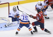 New York Islanders goaltender Semyon Varlamov (40) makes a save on a shot by Washington Capitals right wing T.J. Oshie (77) as Islanders right wing Cal Clutterbuck (15) keeps close during the first period of an NHL Eastern Conference Stanley Cup playoff hockey game in Toronto, Ontario, on Wednesday, Aug. 12, 2020. (Nathan Denette/The Canadian Press via AP)