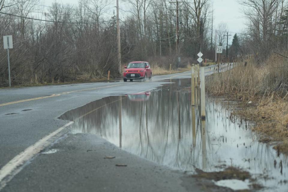 A car drives through the partially flooded W Smith Road on January 29, 2024, near Ferndale, Wash.