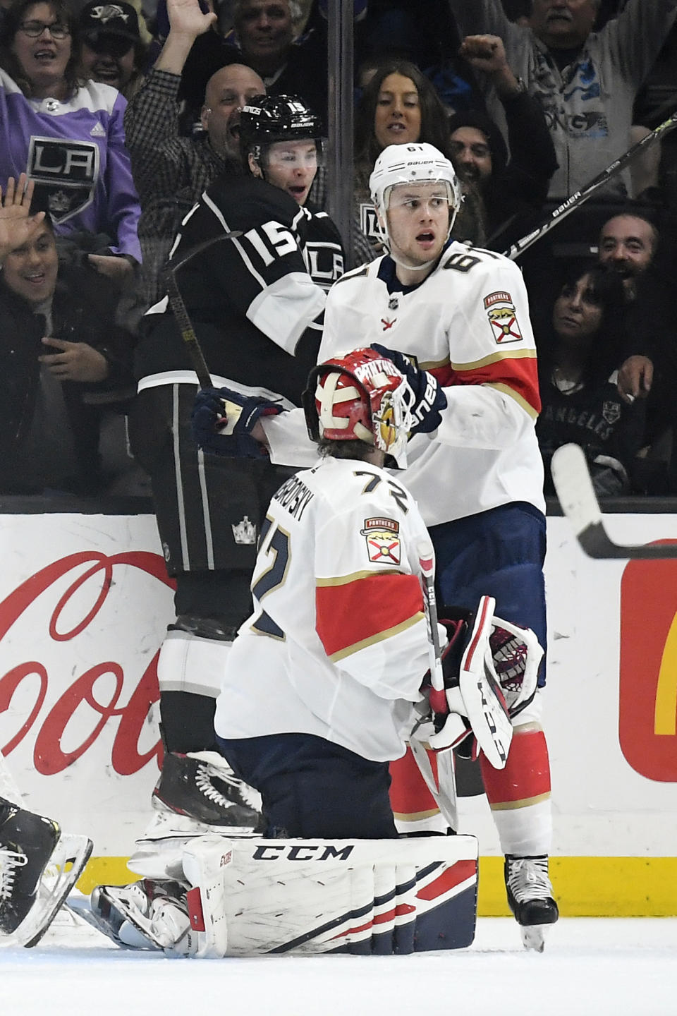 Los Angeles Kings defenseman Ben Hutton, left, celebrates his goal as Florida Panthers goaltender Sergei Bobrovsky, center, kneels on the ice while defenseman Riley Stillman stands by during the third period of an NHL hockey game Thursday, Feb. 20, 2020, in Los Angeles. The Kings won 5-4. (AP Photo/Mark J. Terrill)