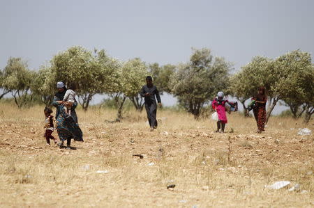 Displaced civilians, who fled the ancient city of Palmyra after Islamic State fighters took control of the area, walk in Gazaleh town, north of Homs, Syria where they are taking shelter June 3, 2015. REUTERS/Omar Sanadiki