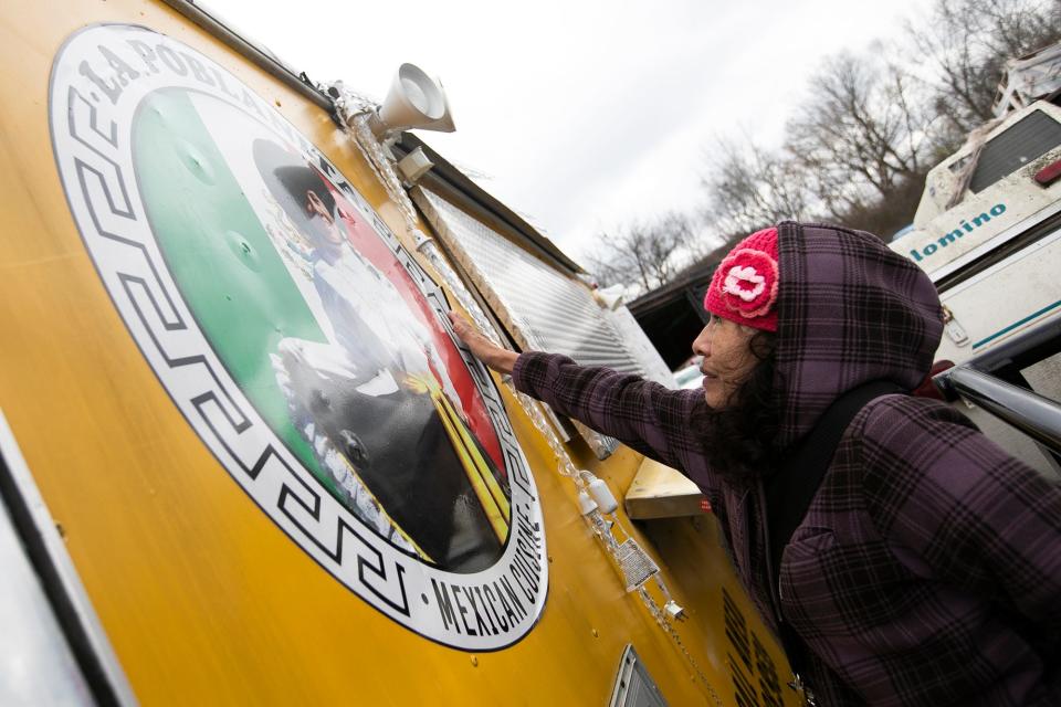 Marcelina Soriano, owner of La Poblanita, a taco and Mexican food trailer usually parked at 3825 Indianola Ave. in Clintonville, touches her photo Monday on the side of her trailer, which was stolen early Saturday morning and stripped of its kitchen equipment and other items. The trailer was found and towed to the Columbus police impound lot, where Soriano and her family came to reclaim the trailer.