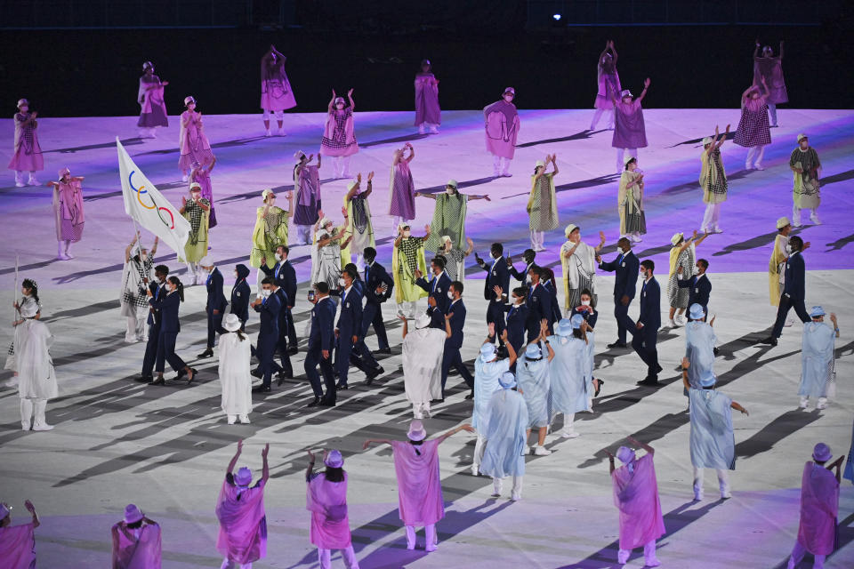 The refugee team carry the Olympic flag during the opening ceremony in the Olympic Stadium at the 2020 Summer Olympics, Friday, July 23, 2021, in Tokyo, Japan. (Dylan Martinez/Pool Photo via AP)