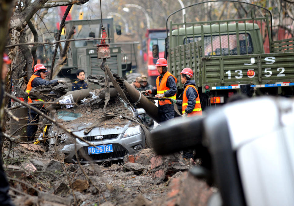 Rescuers search for survivors after an oil pipeline exploded on November 24, 2013 in Qingdao, China. The death toll from the blast that occurred in Huangdao district on Friday morning has risen to 52, with 11 others still missing.  (Photo by ChinaFotoPress via Getty Images) 