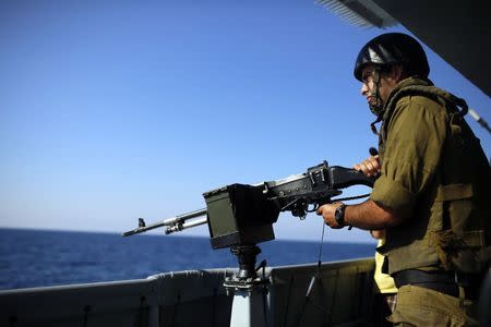 An Israeli soldier holds a machine gun on an Israeli Navy vessel in the Mediterranean sea August 1, 2014.REUTERS/Amir Cohen