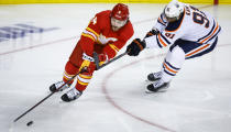 Edmonton Oilers left wing Evander Kane, right, defends as Calgary Flames defenseman Rasmus Andersson turns with the puck during the second period of Game 1 of an NHL hockey second-round playoff series Wednesday, May 18, 2022, in Calgary, Alberta. (Jeff McIntosh/The Canadian Press via AP)