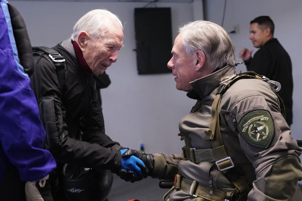 Texas Gov. Greg Abbott, right, prepares to skydive with 106-year-old World War II veteran Al Blaschke, left, Monday, Nov. 27, 2023, in Fentress, Texas. (AP Photo/Eric Gay)