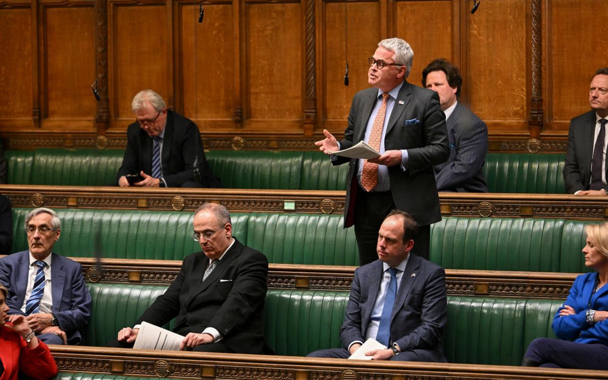 Tim Loughton speaks from the backbenches of the House of Commons, with other MPs seated around him
