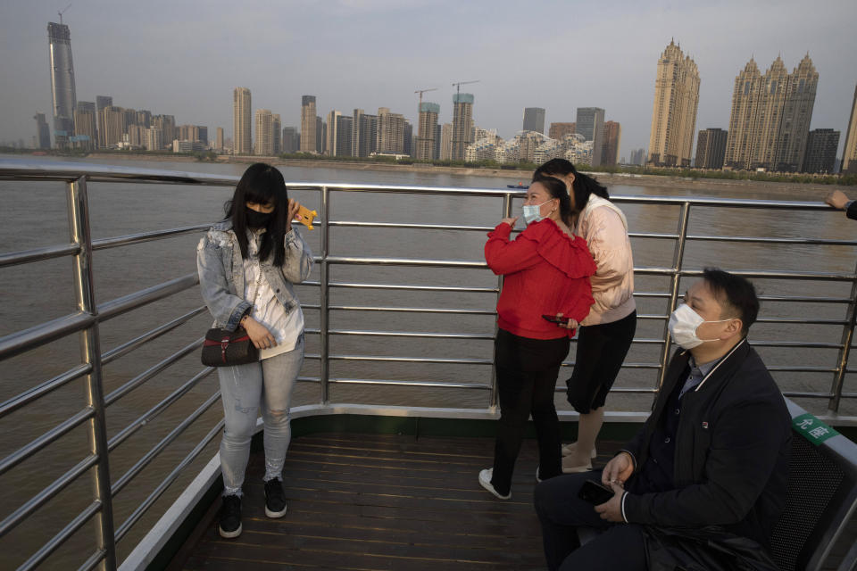 In this April 8, 2020, photo, passengers cross the Yangtze River on a ferry in Wuhan in central China's Hubei province. The reopening of ferry service on the Yangtze River, the heart of life in Wuhan for more than 20 centuries, was an important symbolic step in official efforts to get business and daily life in this central Chinese city of 11 million people back to normal after a 76-day quarantine ended in the city at the center of the coronavirus pandemic. (AP Photo/Ng Han Guan)