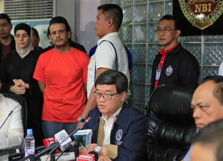 Filipino Justice Secretary Vitaliano Aguirre (C) presents to the media Kuwaiti Husayn al-Dharifi (2nd L) and Syrian Rajaf Zina (L), suspected to have links to Islamic State, during a press conference at the National Bureau of Investigations (NBI) headquarters in metro Manila, Philippines April 6, 2017. REUTERS/Romeo Ranoco