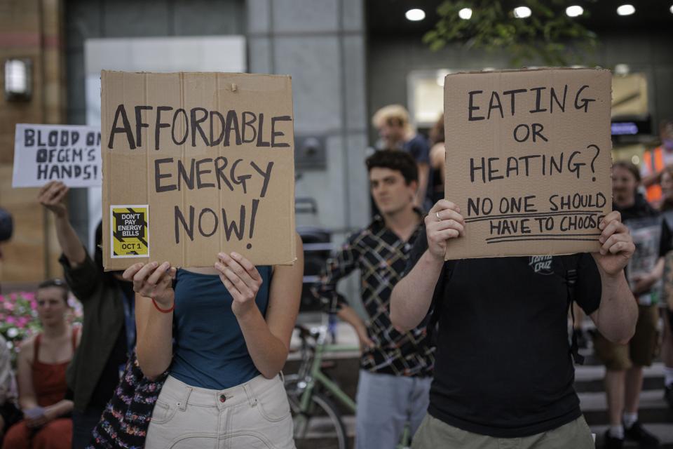 Protesters hold placards during a demonstration against rising energy prices outside Ofgem’s headquarters in Canary Wharf on 26 August 2022 in London, England (Getty Images)