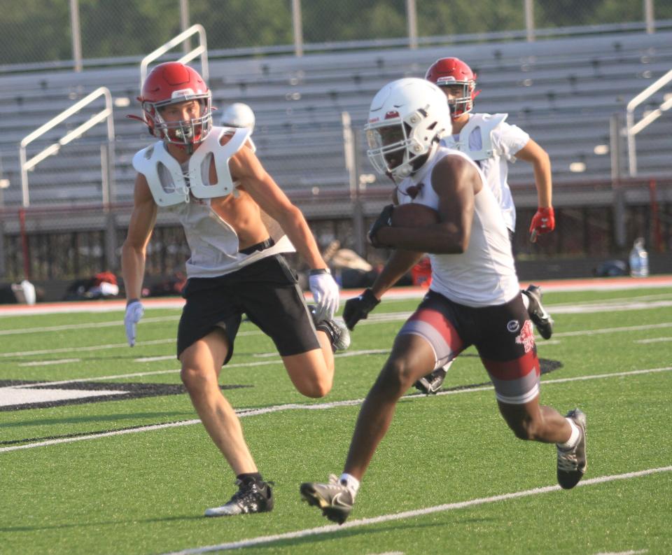 Linden-McKinley's Ta'John Royster cuts across the field after catching a pass with Johnstown's Ronnie Casto in pursuit during a passing scrimmage at Frank H. Chambers Stadium on Tuesday, July 11, 2023.