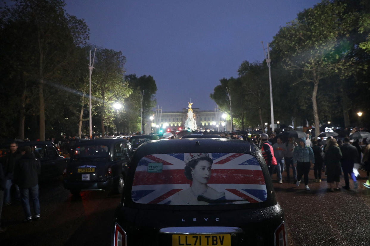 Image: A taxi weaves through crowds of well-wishers on The Mall as people gather outside Buckingham Palace on Thursday. (Isabel Infantes / AFP - Getty Images)