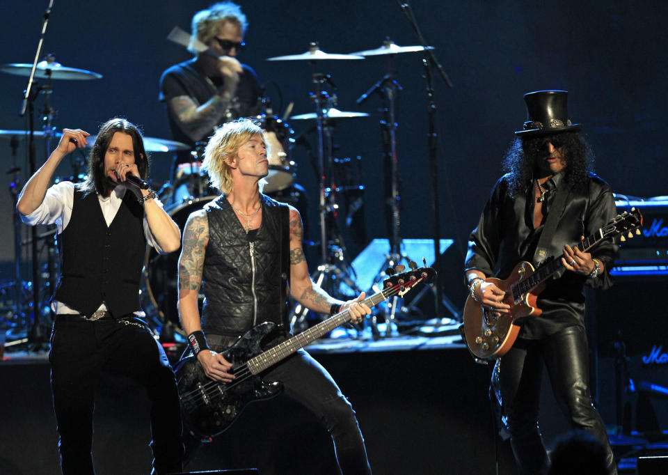 Guns N' Roses' Duff McKagan, center and Slash, right, perform with guest vocalist Myles Kennedy, left, after induction into the Rock and Roll Hall of Fame Saturday, April 14, 2012, in Cleveland. (AP Photo/Tony Dejak)