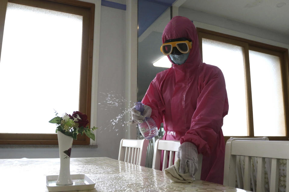 FILE - An employee of Pyongyang Dental Hygiene Products Factory disinfects the floor of a dinning room as the state increased measures to stop the spread of illness in Pyongyang, North Korea on May 16, 2022. According to North Korea, its fight against COVID-19 has been impressive: About 3.3 million people have been reported sick with fevers, but only 69 have died. (AP Photo/Cha Song Ho, File)